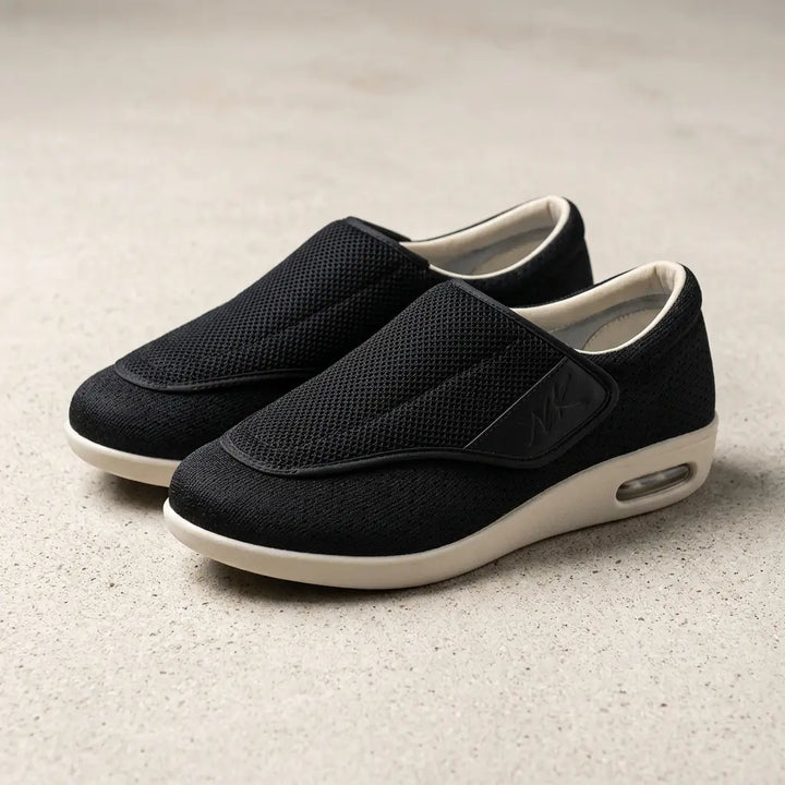 Black mesh slip-on with wide strap and cream air-cushion sole, angled view