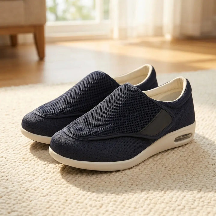 Navy mesh wide-fit slip-on on a rug in a living room, angled view