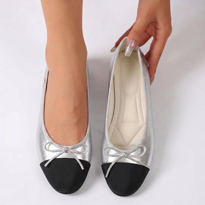 Women's silver metallic ballet flats with black toe cap and bow, flat sole