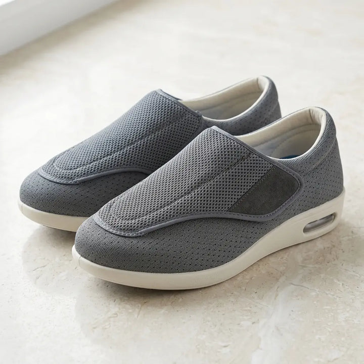 Gray mesh slip-on, wide adjustable strap, cream cushioned sole, angled view