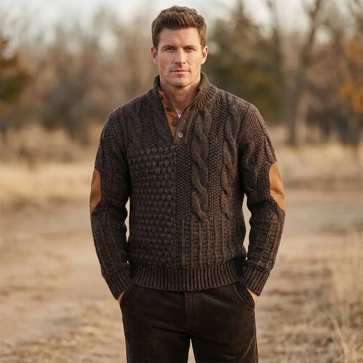 Men's cable knit sweater in brown showing textured cable pattern and elbow patch detail, front model view