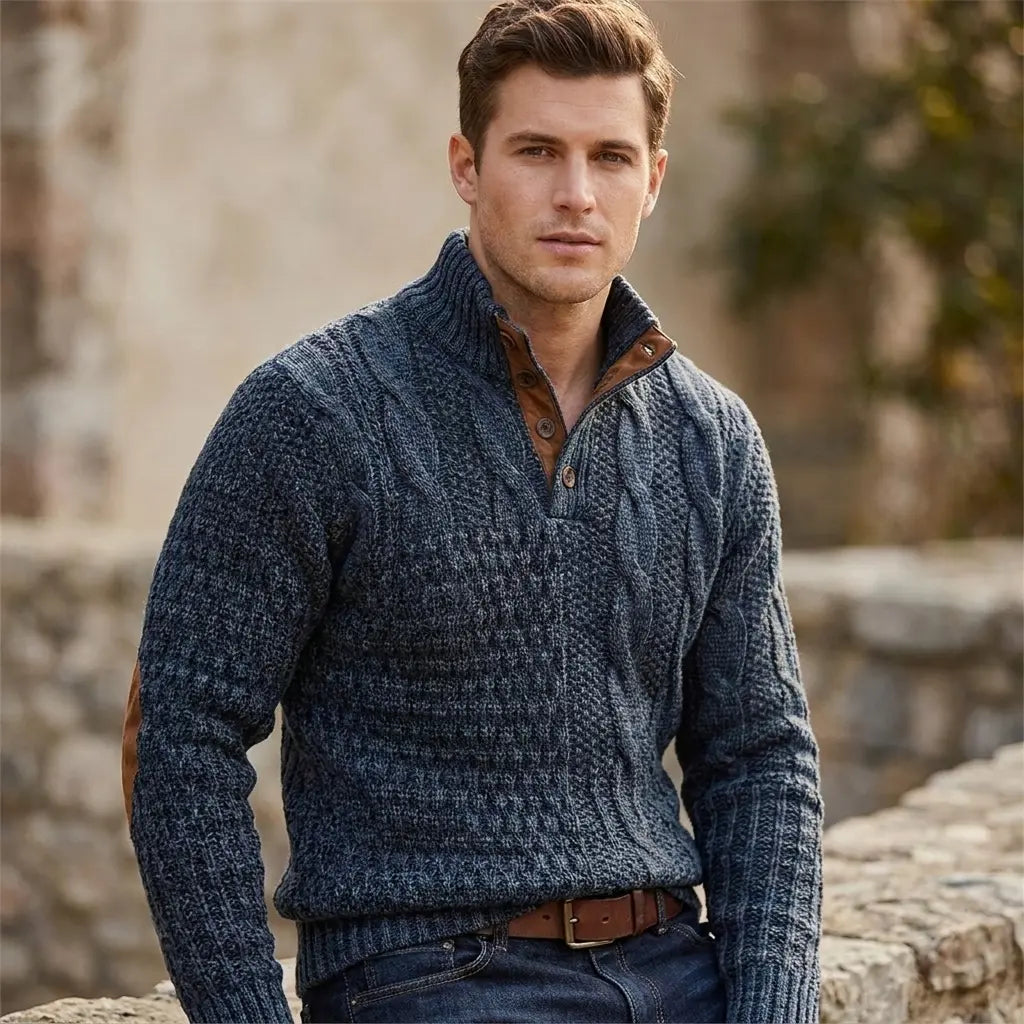 Men's cable knit sweater in dark navy with elbow patches and half-button collar, front model view