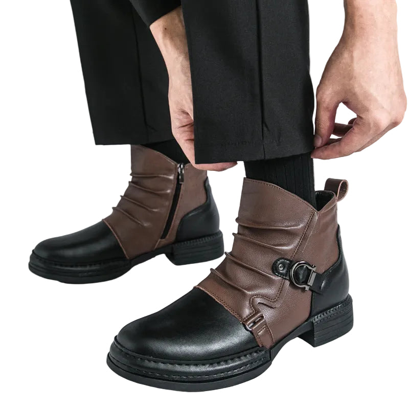 Brown and black leather-look boots with buckle strap worn on light gray background