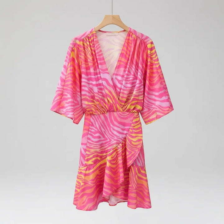 Mini wrap dress with batwing sleeves in pink and orange zebra print on hanger