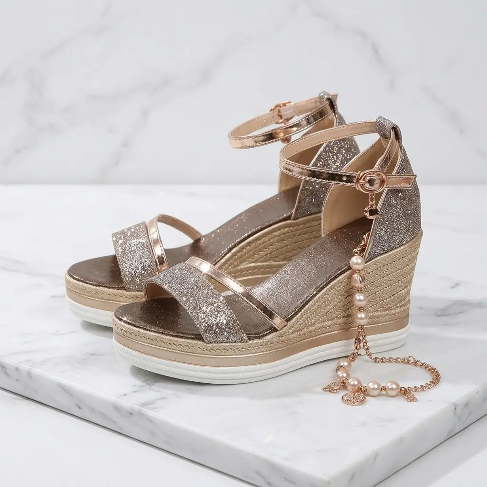 Rose gold glitter wedge sandals with pearl charm and jute espadrille wedge on marble, side pair view