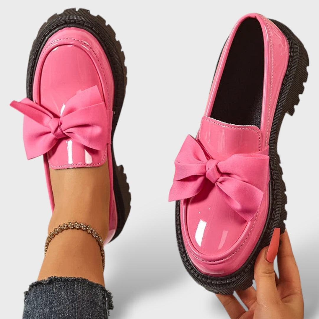 Pink patent leather platform loafers with bow, top and side view on foot and held in hand