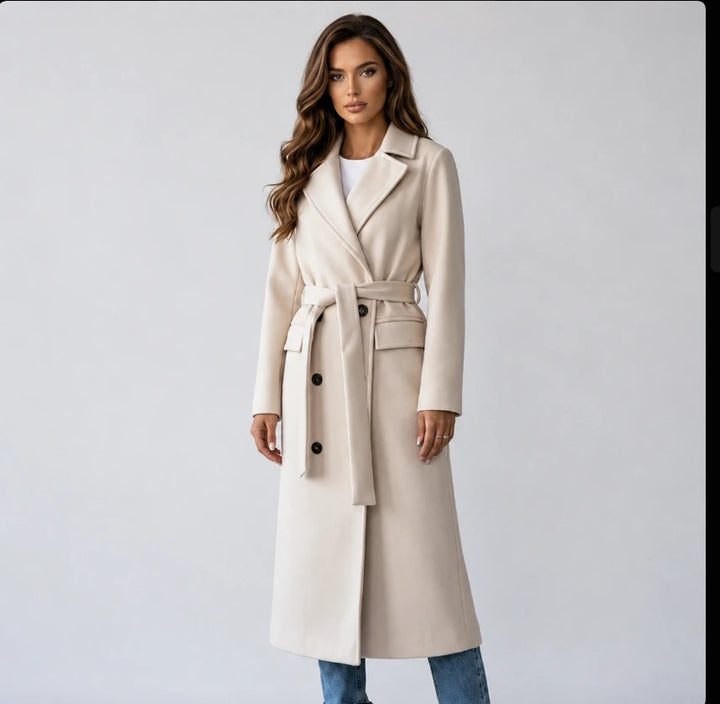 Women's long double-breasted belted coat in cream, front view on model