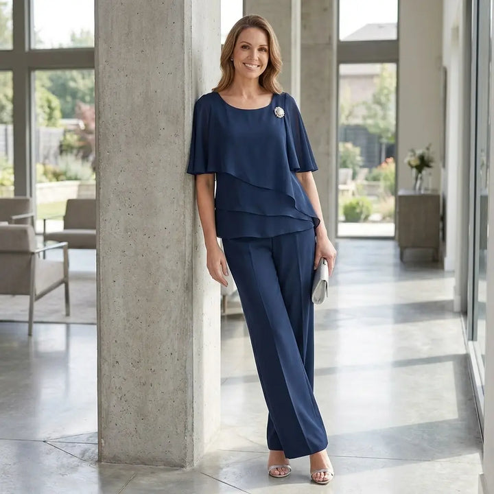 Navy blue layered top and straight-leg trousers set, lifestyle pose leaning against pillar
