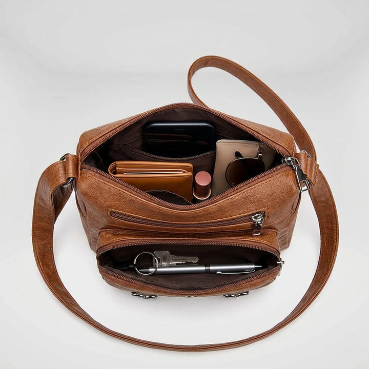 Brown structured shoulder bag flat lay with adjustable strap detail