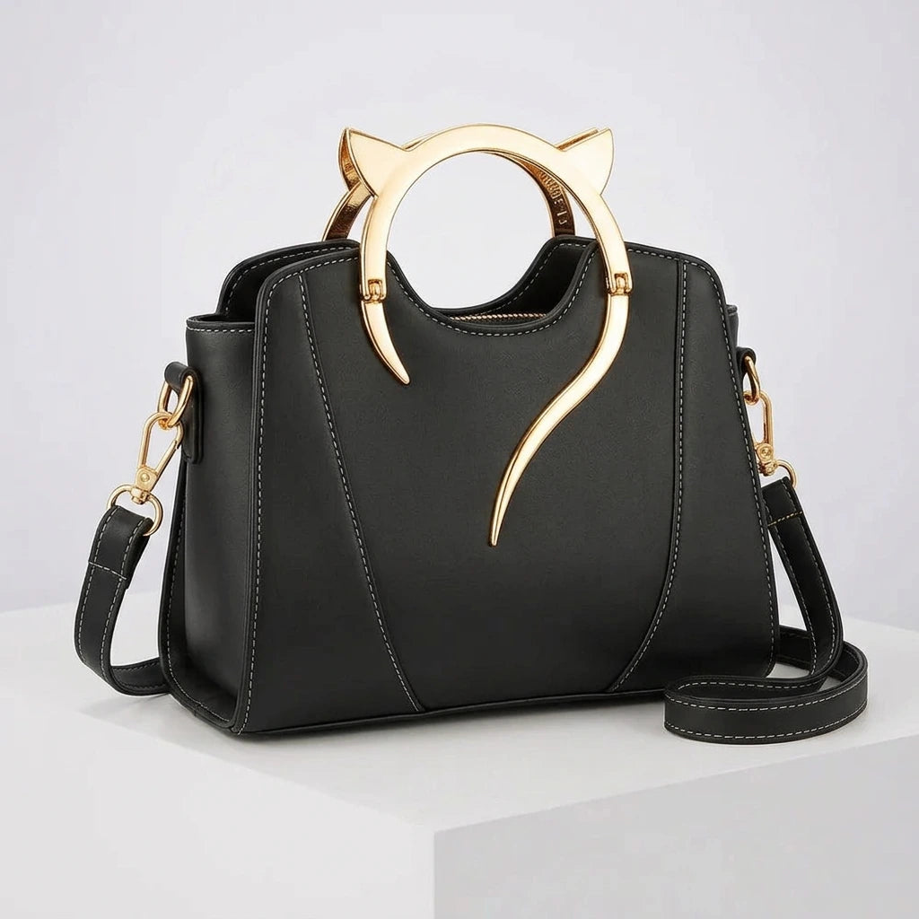 Front view of women's handbag with cat handle — gold cat-ear ring, structured black PU exterior and dual carry options