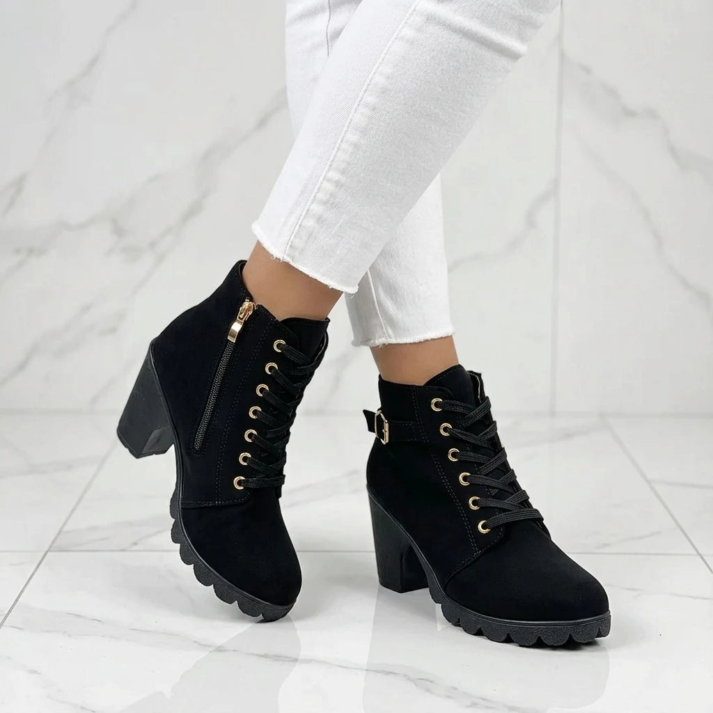 Side view of black ankle boots with side zipper and lug sole