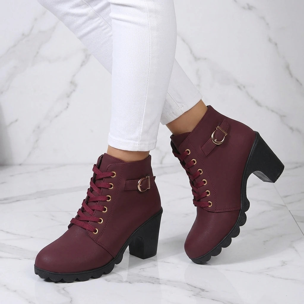 Decorative buckle strap detail on black ankle boots