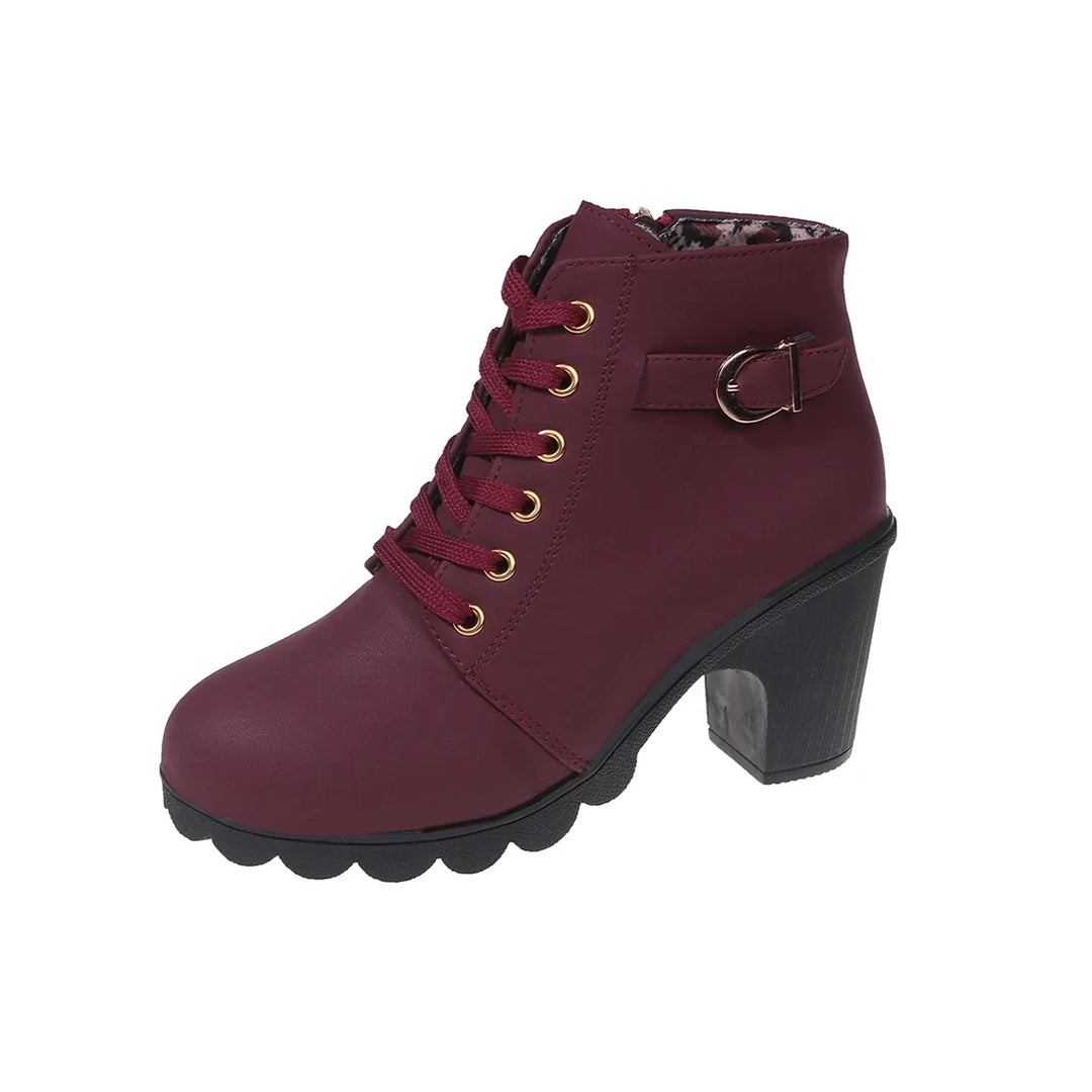 Close-up of gold-tone eyelets and lace-up front on black boots