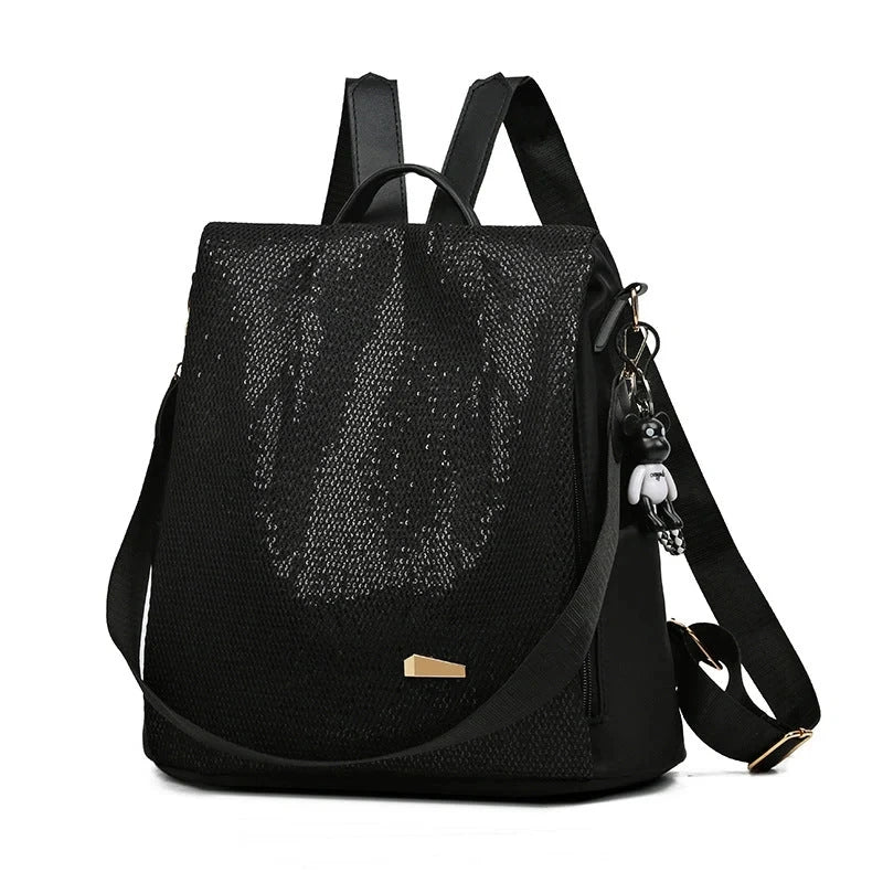 Anti-theft backpack with crossbody strap and charm pendant