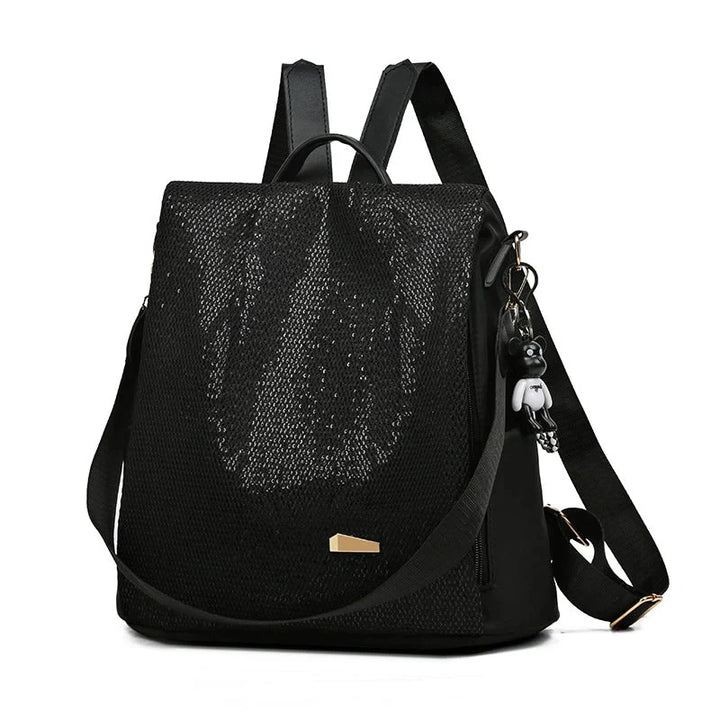 Anti-theft backpack with crossbody strap and charm pendant