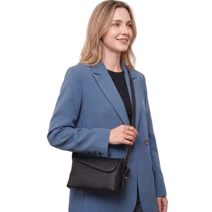 Woman wearing compact black leather crossbody bag on shoulder, front view