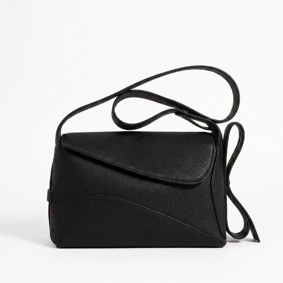 Compact crossbody bag with curved seam panel and magnetic buckle, front view