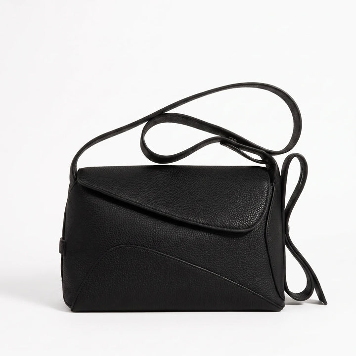 Compact crossbody bag with curved seam panel and magnetic buckle, front view