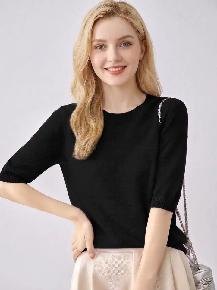Crewneck knit pullover top in black with ribbed cuffs, front view