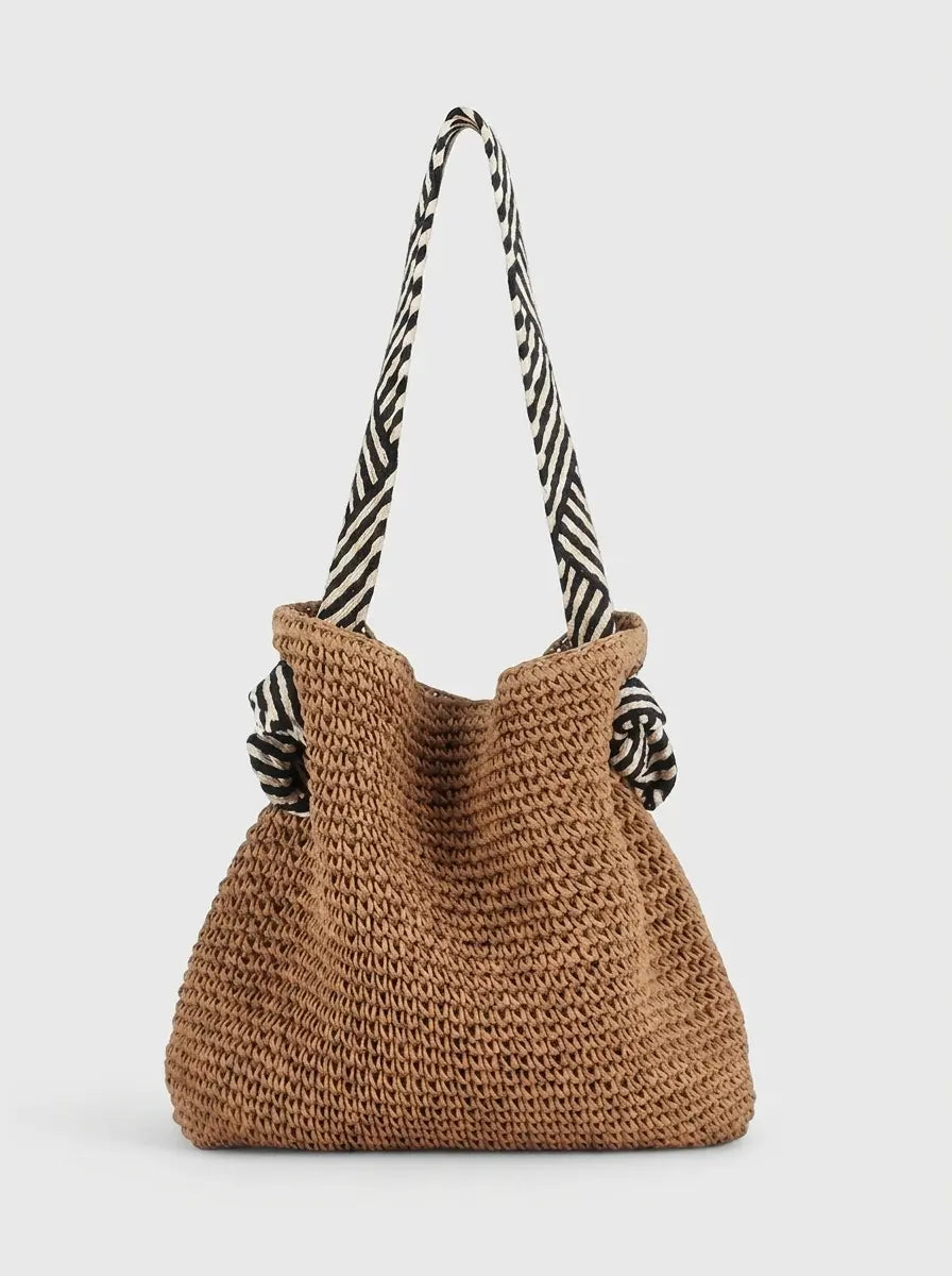Woven shoulder bag in warm brown with striped fabric strap, flat lay