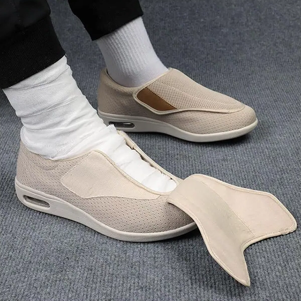 Beige wide-fit slip-on worn with white sock, strap open, side view