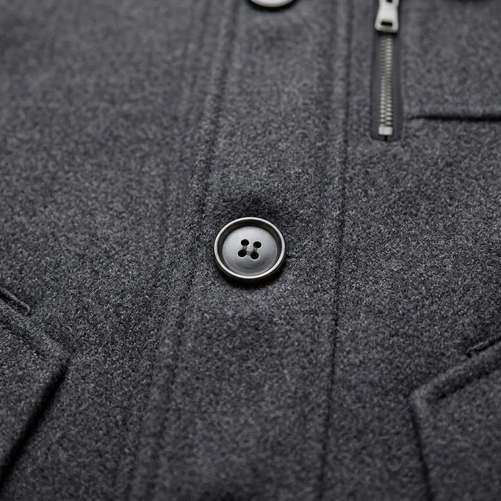 Close-up of men's overcoat button and chest zip pocket detail