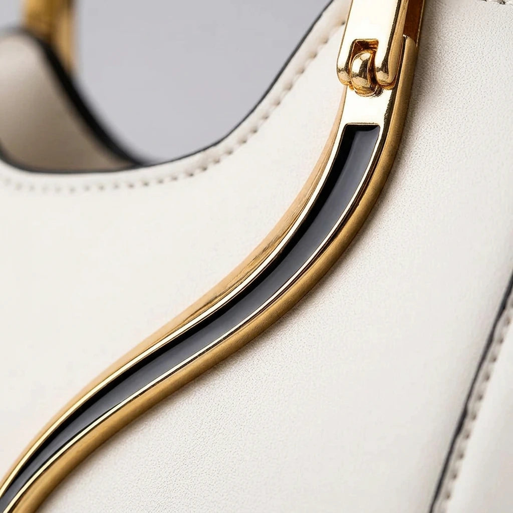 Close-up of gold cat-ear ring handle on black PU handbag