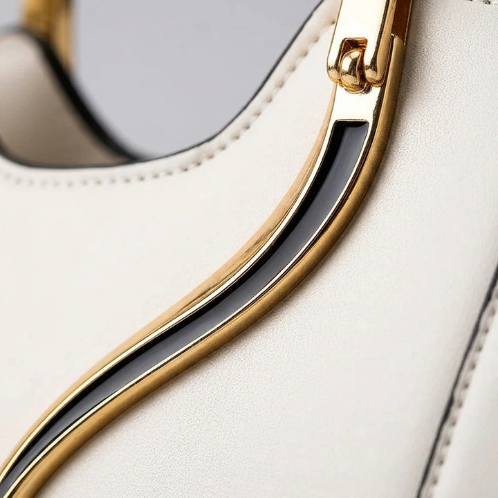 Close-up of gold cat-ear ring handle on black PU handbag