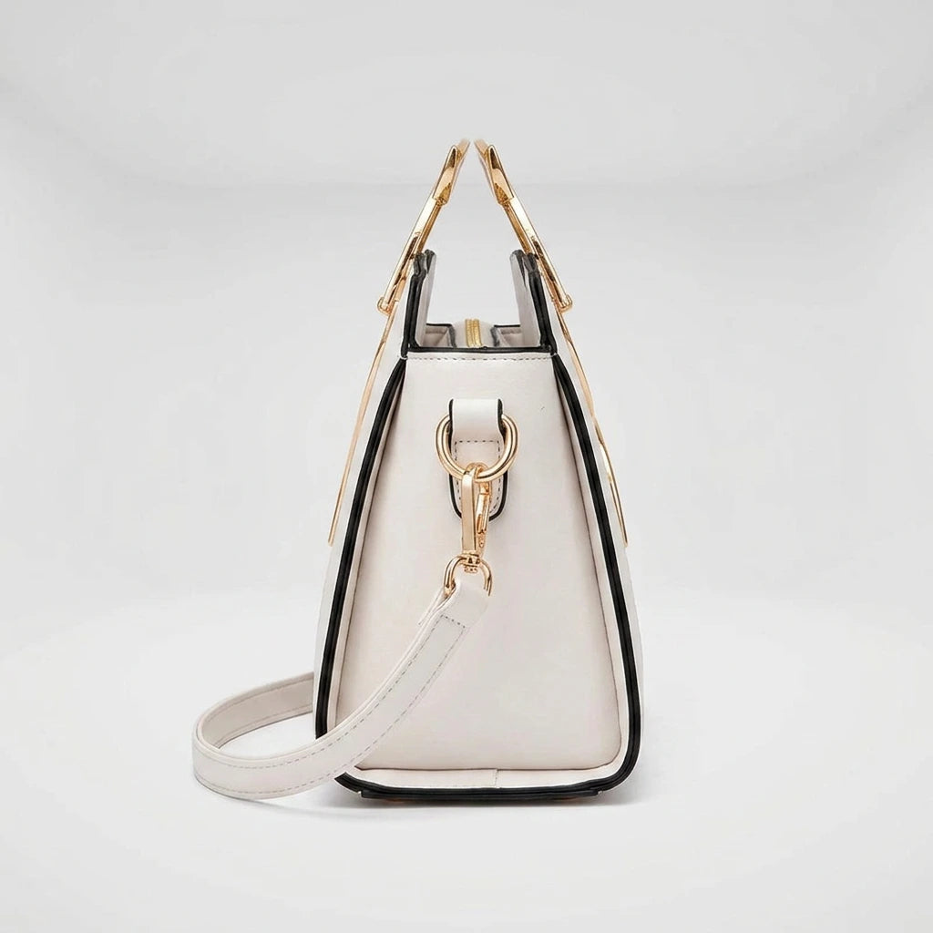 Side profile of black cat handle handbag — structured arch shape and adjustable crossbody strap
