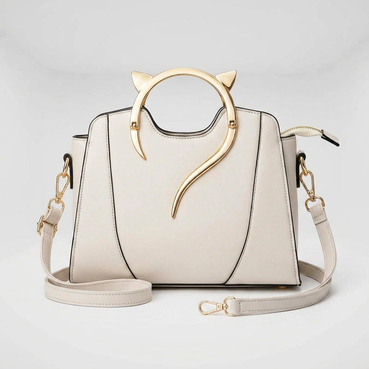 Women's handbag with cat handle — top-down view showing gold cat-ear ring handle and structured black PU exterior